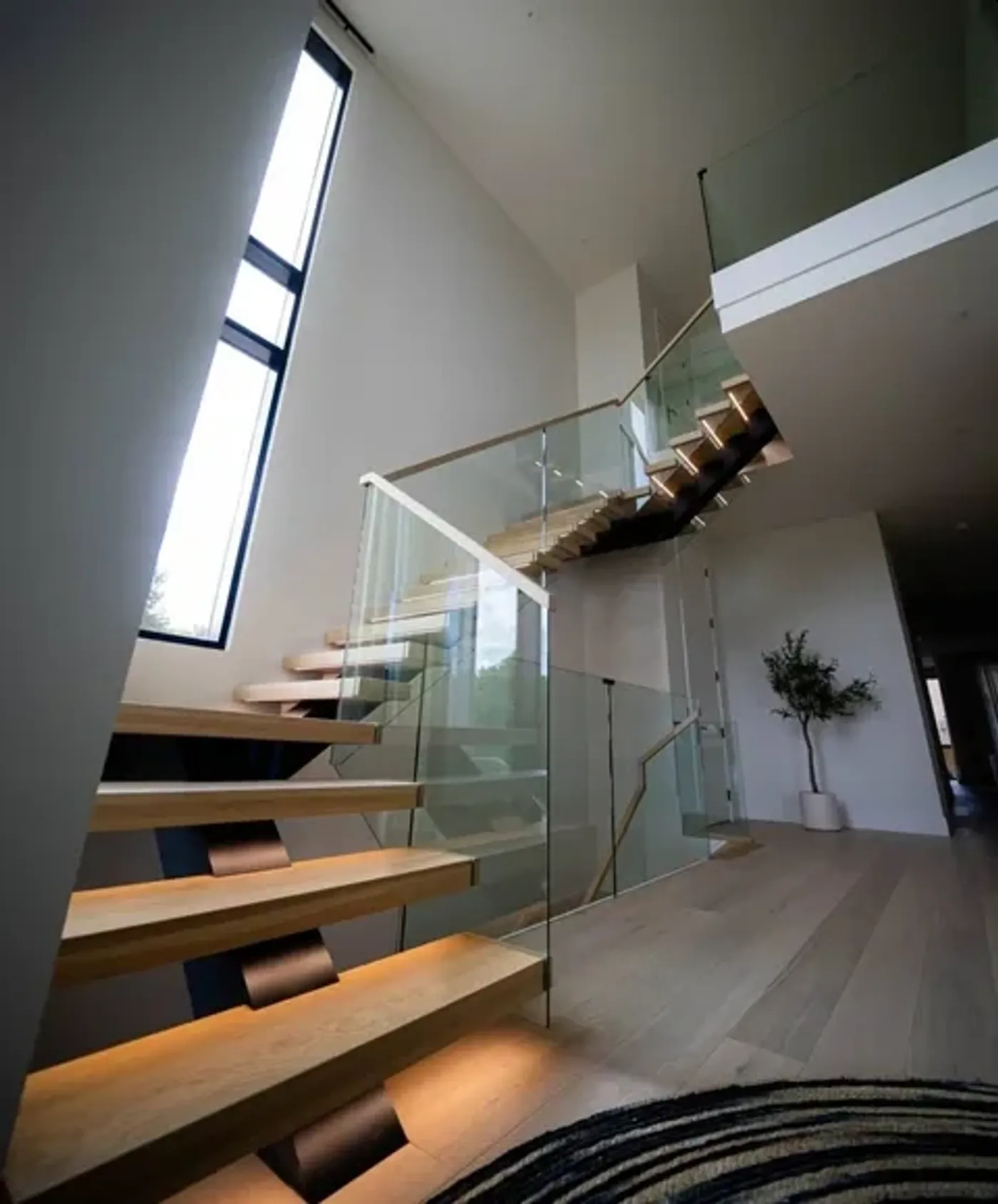Custom frameless glass balustrade railing system on a floating stair in Nassau County